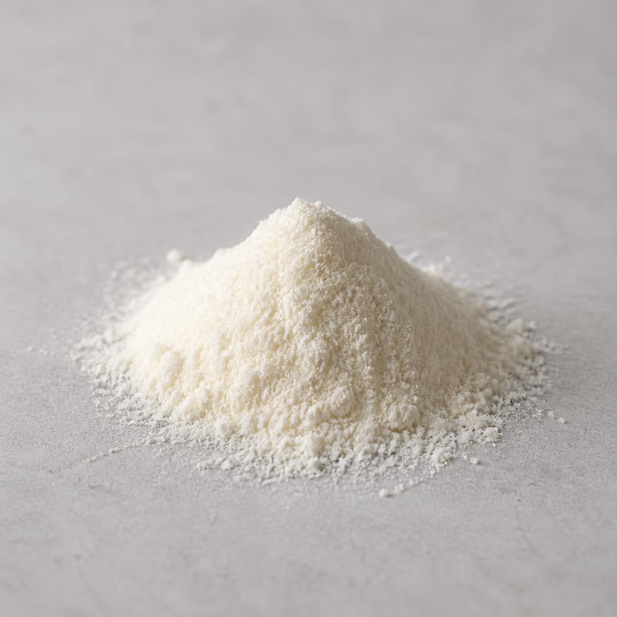 Fine hydrolyzed whey protein powder on a neutral stone surface